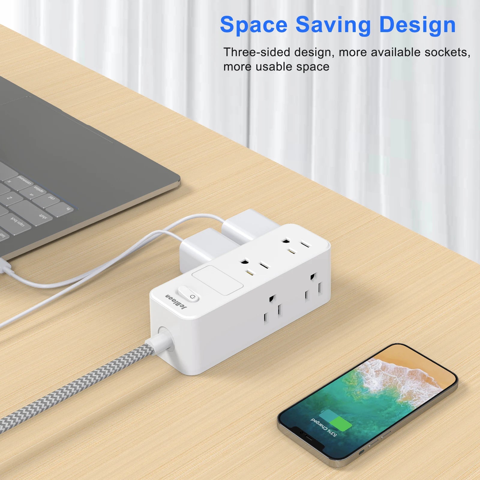 White power strip with multiple outlets on a wooden desk next to a laptop and smartphone, with text highlighting space-saving design.