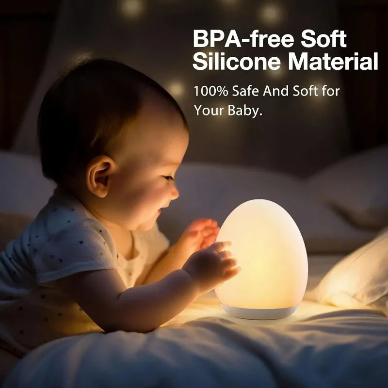 Baby interacting with a soft silicone night light in a dimly lit room.