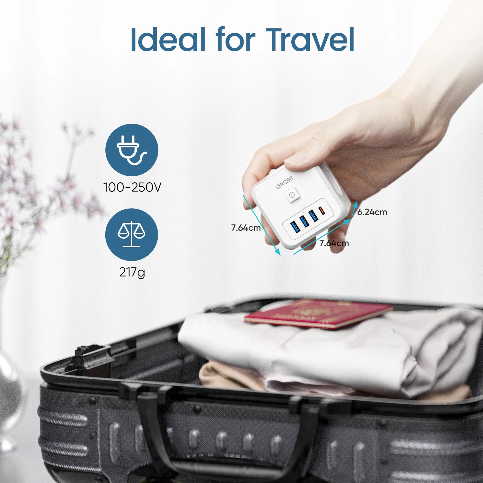 Hand holding a white USB adapter with specifications, next to an open suitcase with clothes and a passport.