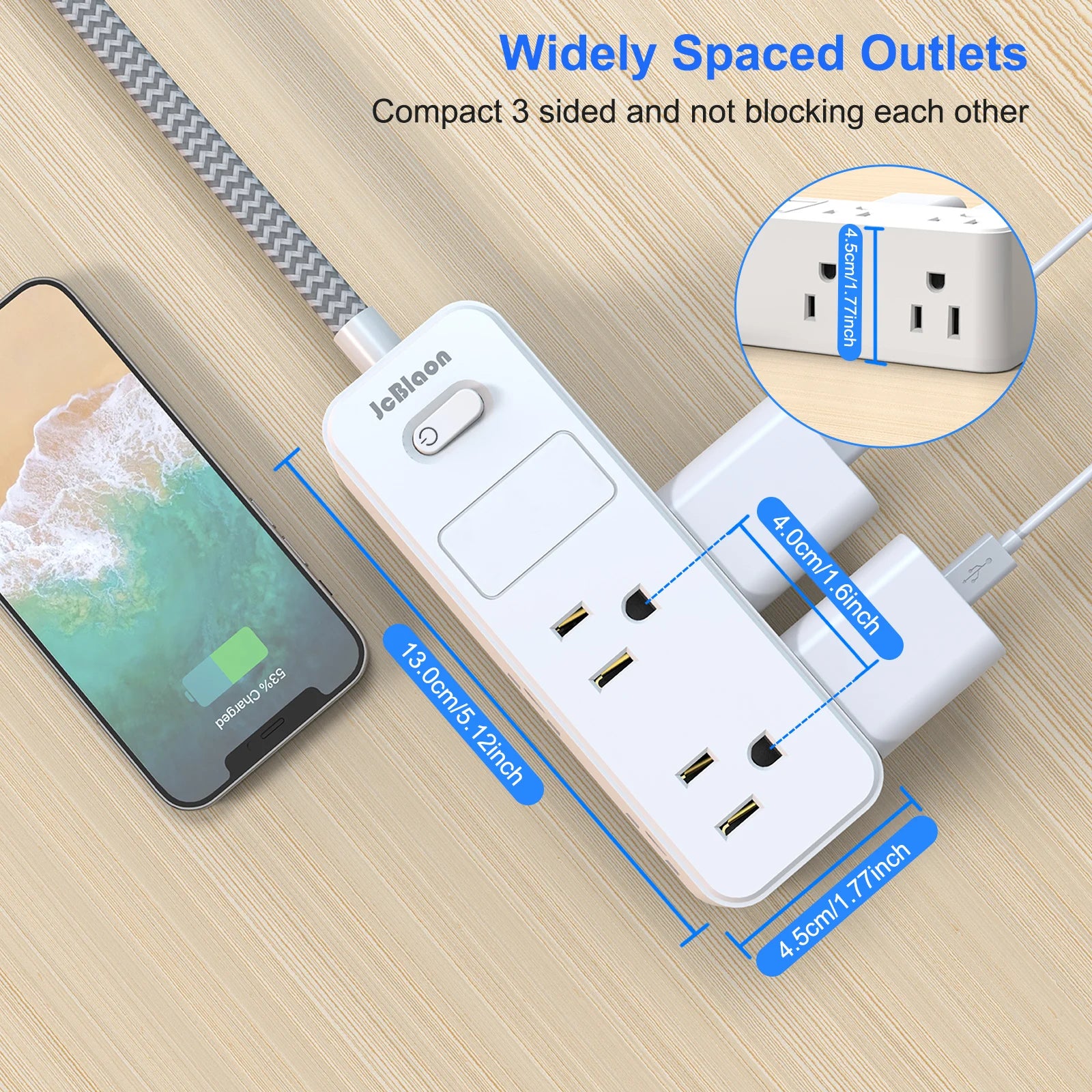 White power strip with multiple outlets and USB ports on a wooden surface, with a smartphone beside it.