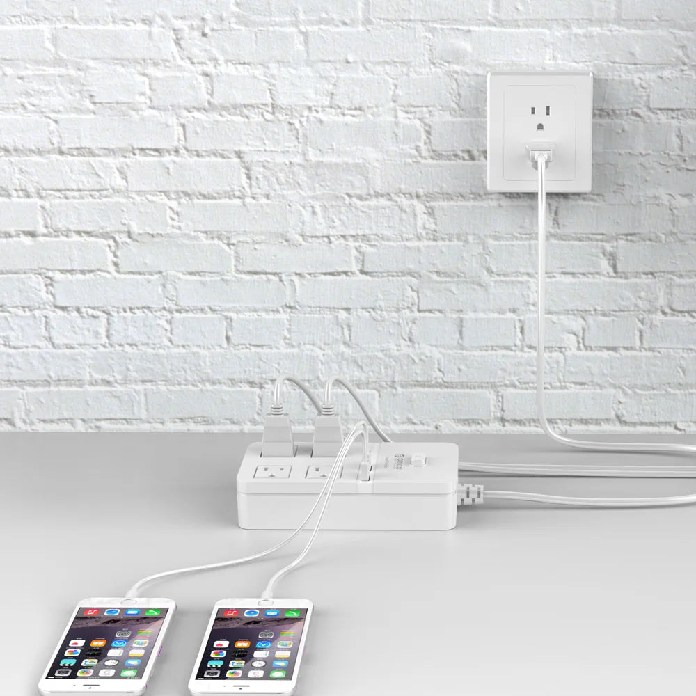 White power strip with multiple outlets and USB ports on a white brick wall background.